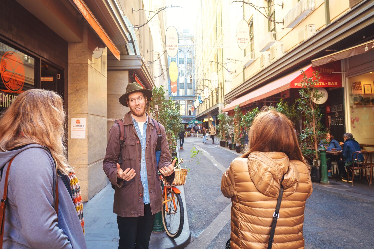 A Depot Adventures guide telling a story to two guests in a Melbourne laneway