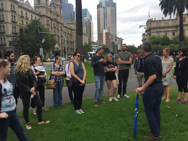 A guide briefing a tour group on the grass at Gordon Reserve in 2017