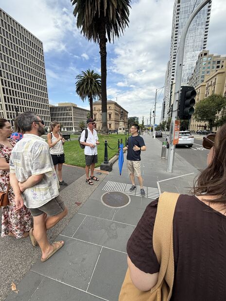 Guide Simon leading a food tour group across a city street in 2026