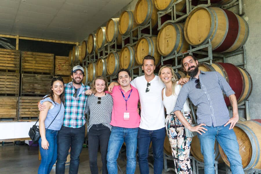 A group of guests photographed together in a winery barrel room
